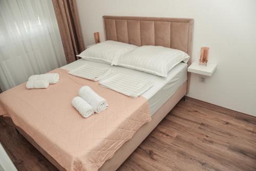 a bed with two white towels on top of it at S&L luxury apartman in Banja Koviljača