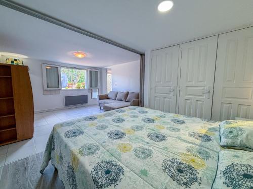 une chambre avec un lit et un canapé dans l'établissement Charmant rez-de-villa avec piscine et terrasse, au Plan-de-la-Tour