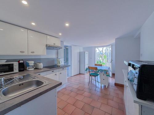 une cuisine avec un évier et un plan de travail dans l'établissement Charmant rez-de-villa avec piscine et terrasse, au Plan-de-la-Tour