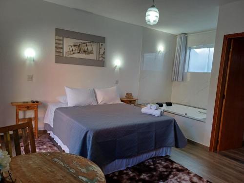 um quarto de hotel com uma cama e uma banheira em Refugio Victoria em Monte Verde