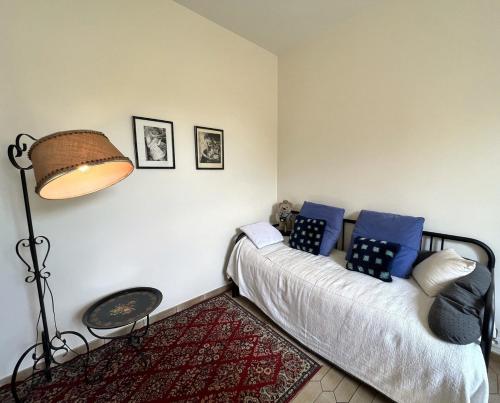 a bedroom with a bed with blue pillows and a lamp at Gîte Chinon, chez Marie in Chinon