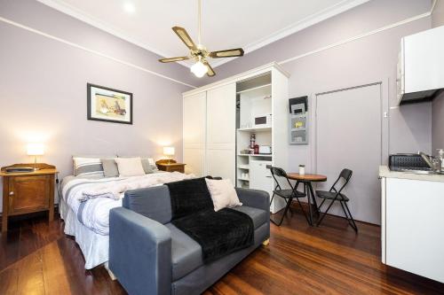 a bedroom with a bed and a couch and a ceiling fan at Dawson Accommodation in Fremantle