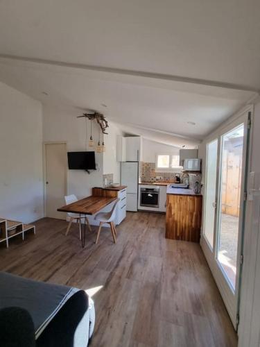 un salon avec une table et une cuisine dans l'établissement Maison au calme proche calanques, à Marseille