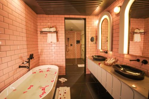 - Baño rosa con 2 lavabos y bañera en Pushpak Grande en Kondotti