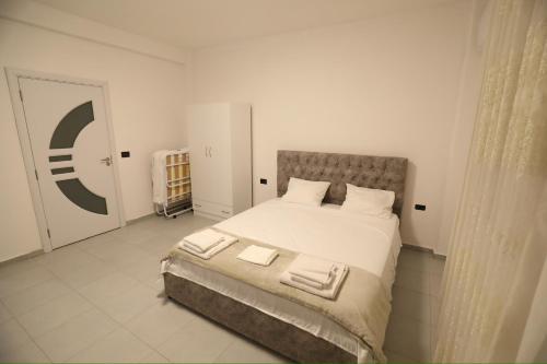 a white bedroom with a large bed with white sheets at Casa Del Sol Pogradec in Pogradec