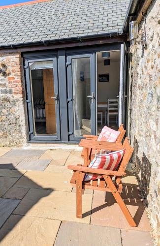 a wooden bench sitting in front of a building at Sterennyk in Helston