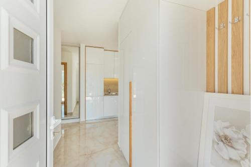 a white hallway with white cabinets and a mirror at Bella Vista Luxure Apartments in Baošići
