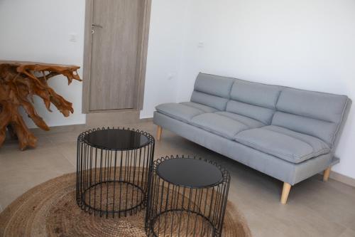a living room with a blue couch and two chairs at Amuse Mykonos Boutique Hotel in Mýkonos City