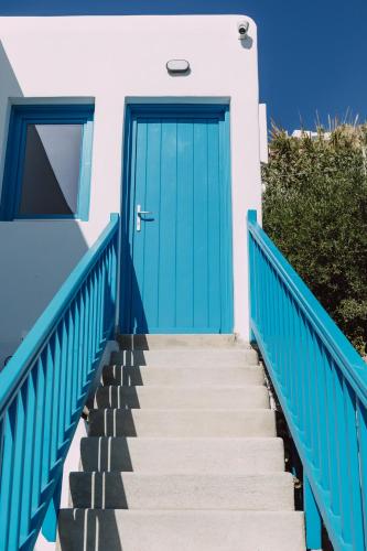 a blue door on a white house with stairs at Amuse Mykonos Boutique Hotel in Mýkonos City