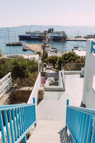a dock with two blue benches and a cruise ship at Amuse Mykonos Boutique Hotel in Mýkonos City