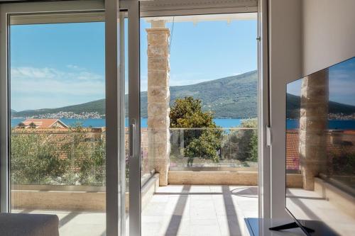 a view from the living room of a house with sliding glass doors at Bella Vista Luxure Apartments in Baošići
