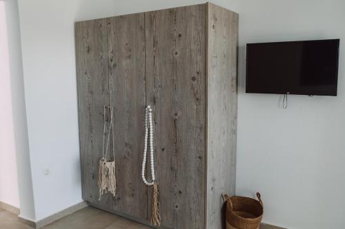 a wooden cabinet with a tv on a wall at Amuse Mykonos Boutique Hotel in Mýkonos City
