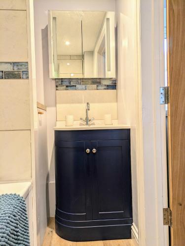 a bathroom with a black sink and a mirror at Sterennyk in Helston