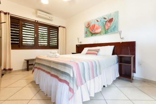 a bedroom with a large bed in a room at Chalé em Pipa por Carpediem in Pipa