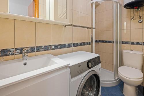 a bathroom with a washing machine and a toilet at Apartment Bellistra Rabac in Rabac
