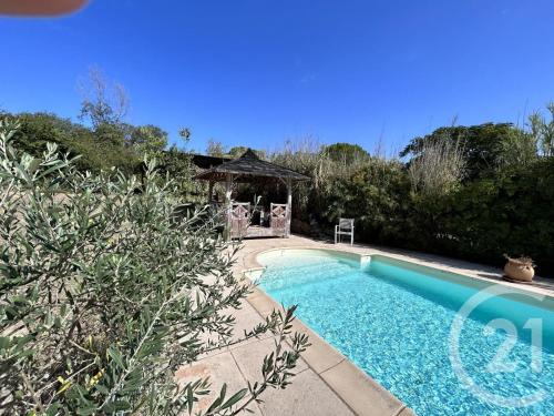 - une piscine dans une cour avec un kiosque dans l'établissement Le chant du Cèdre, à Gabian