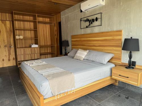 a bedroom with a large bed with a wooden headboard at Nabani Condominios T3 in Santa Cruz Huatulco