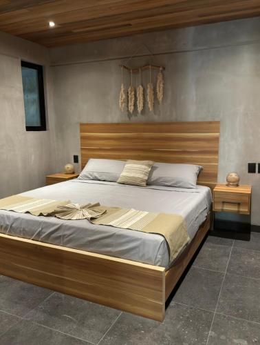a bedroom with a large bed with a wooden headboard at Nabani Condominios T3 in Santa Cruz Huatulco