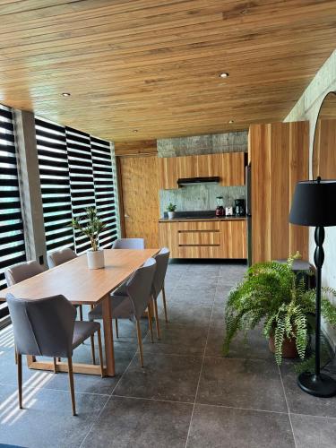 a dining room with a wooden table and chairs at Nabani Condominios T3 in Santa Cruz Huatulco