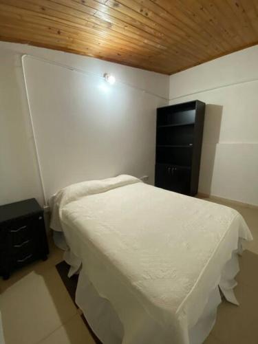 a small bedroom with a bed and a television at Departamento 2 Pellegrini in Posadas