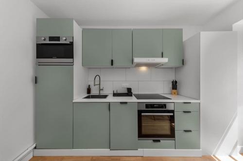 une cuisine blanche avec des armoires et des appareils blancs dans l'établissement Duplex 6 Personnes Hyper Centre, à Dieppe