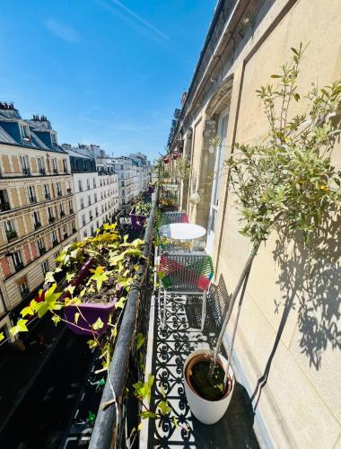 - un balcon avec des chaises et des plantes en pot dans un bâtiment dans l'établissement Mon Cocon Parisien, à Paris
