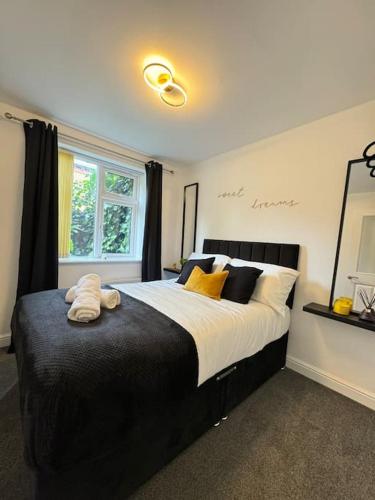 a bedroom with a large bed with yellow and black pillows at Luxury cozy 3 bed Apartment 5mins from city - free parking! in Nottingham
