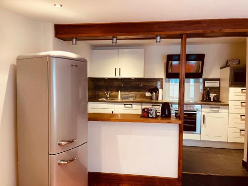 a kitchen with white cabinets and a refrigerator at Fewo Coburg - Ferienwohnung - Möblierte Wohnung in Coburg
