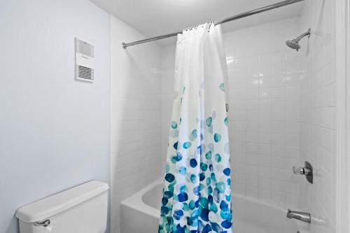 a bathroom with a shower with a blue and white shower curtain at SunDestin Resort Unit 0814 in Destin