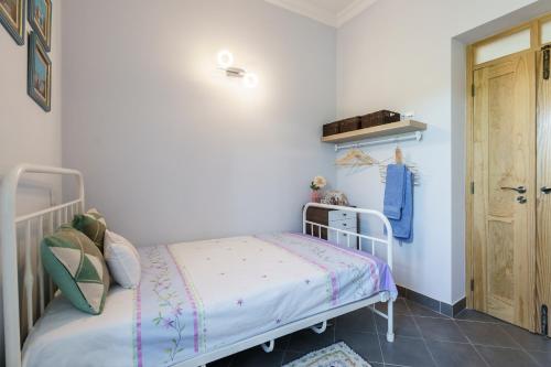 a small bedroom with a bed and a door at Casa D'Nossa, casa tradicional e Moderna, vista 360º, piscina de agua salgada in Luz de Tavira