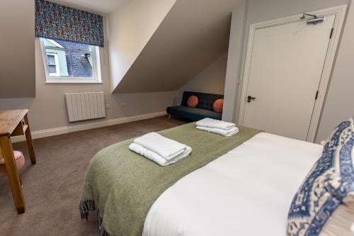a bedroom with a bed with two towels on it at The Town Crier, Tenby in Tenby