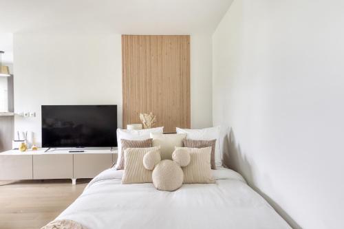 - une chambre blanche dotée d'un lit avec des oreillers et d'une télévision dans l'établissement Disneyland - Val d'Europe à pied - Paris, à Serris