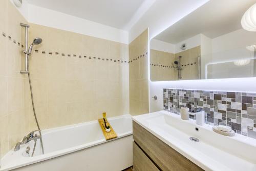 une salle de bain avec une baignoire, un lavabo et un miroir dans l'établissement Disneyland - Val d'Europe à pied - Paris, à Serris