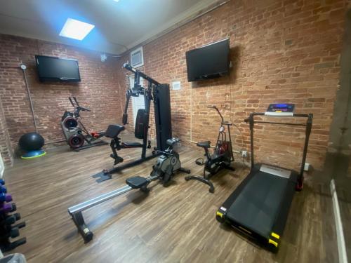 a gym with exercise equipment and a brick wall at Quarter House Suites in New Orleans