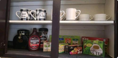 a shelf with coffee cups and other items on it at Be Our Guest-Shared Home Tampa in Palmdale