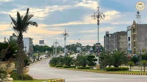 a street in a city with palm trees and buildings at Vip homes jhelum in Jhelum