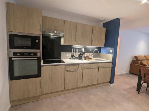 une cuisine avec des armoires en bois et un four à plaques de cuisson dans l'établissement Là-haut au Lacblanc, à Orbey