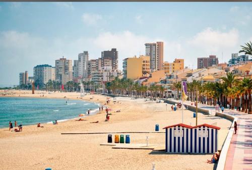 una playa con gente y el océano y una ciudad en BUNGALOW CAMPELLO, en El Campello