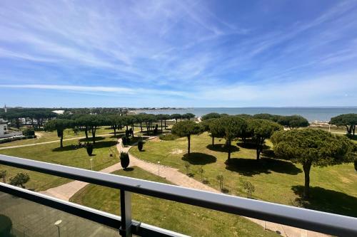 une personne debout sur un balcon donnant sur un parc dans l'établissement L'Horizon - Exceptionnelle vue mer avec terrasse et parking, au Grau-du-Roi