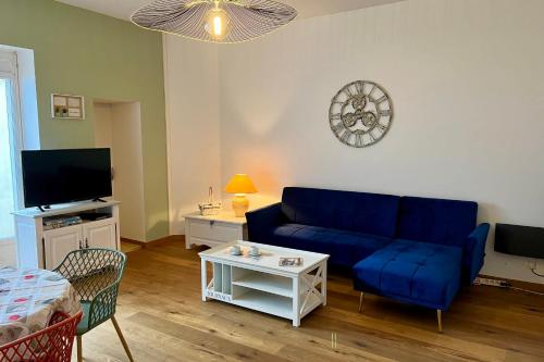 un salon avec un canapé bleu et une télévision dans l'établissement Maison 