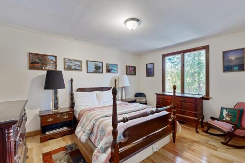 a bedroom with a bed and a desk and a window at Ladyslipper Cottage in Somesville