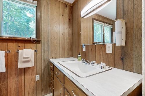 a bathroom with a sink and a mirror at Ladyslipper Cottage in Somesville