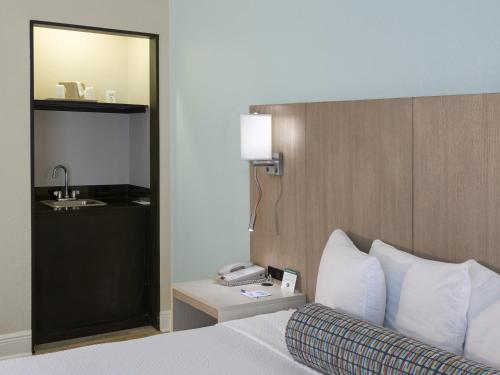 um quarto de hotel com uma cama e um lavatório em Galleria Palms Orlando - Free Theme Park Shuttles em Orlando