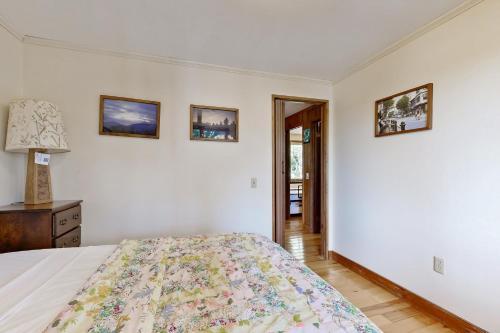 a bedroom with a bed and three pictures on the wall at Ladyslipper Cottage in Somesville