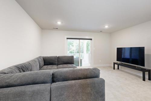 a living room with a gray couch and a flat screen tv at The Peninsula --- 22198 Dune Cir in Millsboro