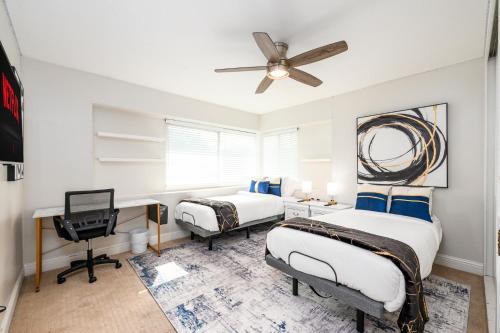 una camera da letto con due letti e una scrivania con un computer di Resort Style Living with Pool, Arcade, Near Disney a Fullerton