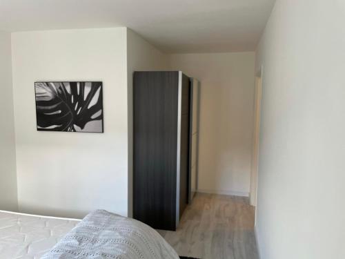 - une chambre avec un lit et une armoire noire dans l'établissement Appartement 24h du Mans, au Mans