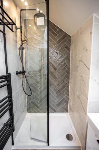 a shower with a glass door in a bathroom at The Town Crier, Tenby in Tenby