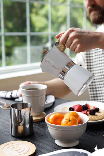 a person is pouring coffee into a bowl of fruit at Riverside Retreat on Skagit River in Concrete
