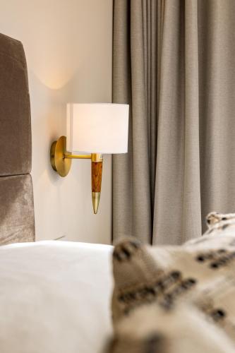 a lamp on a wall next to a bed at The Town Crier, Tenby in Tenby